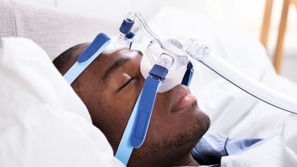 Homem dorme tranquilamente com mascara CPAP